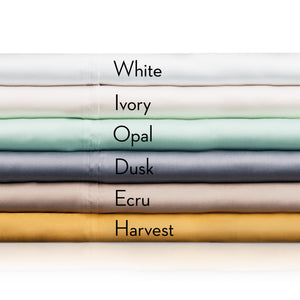 Woven Tencel Lyocell Sheet Set for the firehouse in six colors folded on top of one another including: white, ivory, opal, dusk, ecru, and harvest